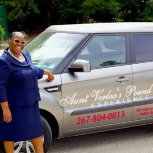 woman in blue outfit standing infront of a branded car