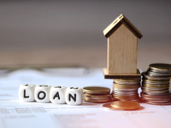 Ellis Street Lending dice spelling 'loan', 3 stacks of coins with a small wooden house balancing on the middle stack of coins