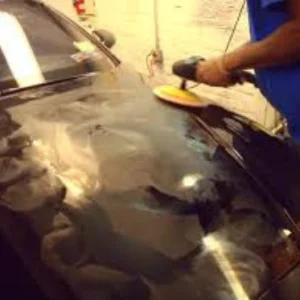 buffing machine against a black car