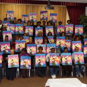 group of people holding up their paintings of a cross