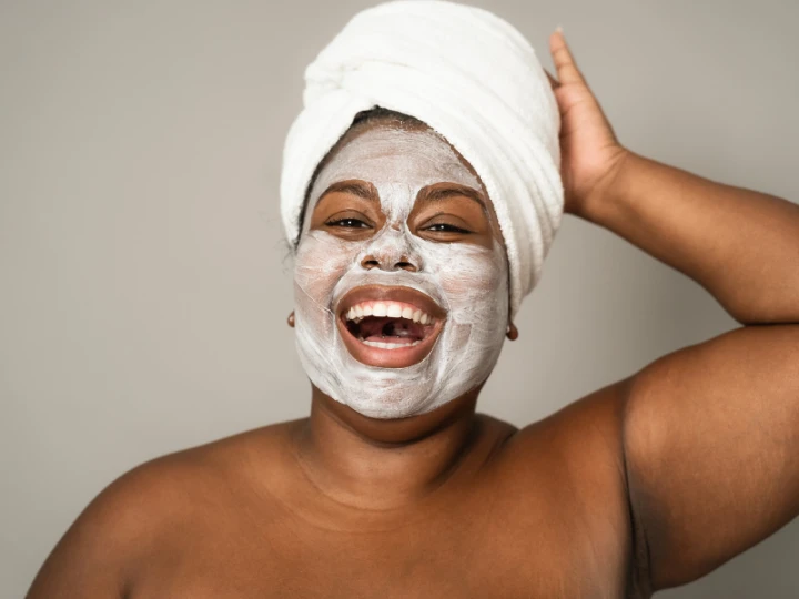 Pink Diamond Beauty Mall woman smiling with a towel on her head and a face mask on